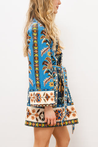 Woman wearing a colorful patterned dress on a white background