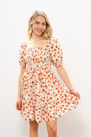 Woman wearing a floral dress with a plain background