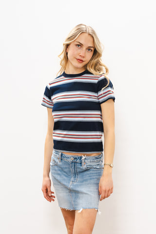 Woman wearing a striped shirt and denim skirt on a white background