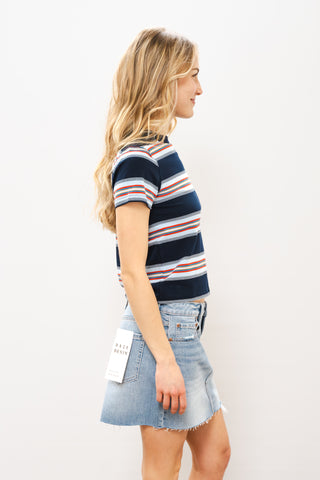 Woman wearing a striped shirt and denim skirt on a white background