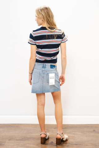 Woman wearing a striped shirt and denim skirt on a white background