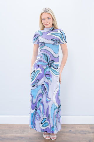 Woman wearing a colorful patterned dress against a white background
