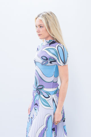 Woman wearing a colorful dress with abstract patterns on a white background