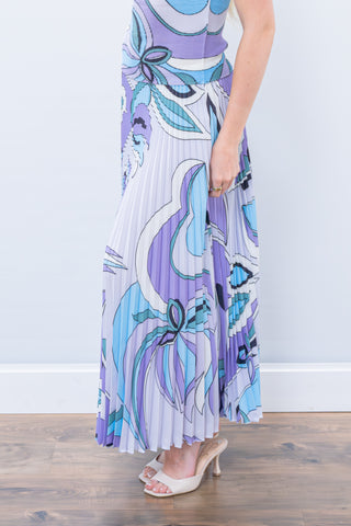 Person wearing a long, patterned dress with a white background