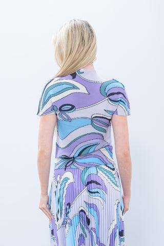 Woman wearing a colorful abstract patterned dress on a white background