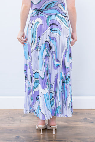 Woman wearing a long, patterned dress with a white background