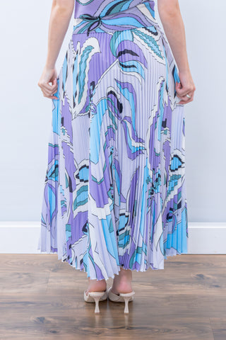 Person wearing a long, patterned dress with a white background