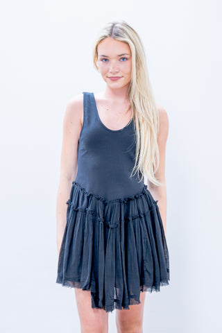 Woman wearing a dark blue dress with a plain background