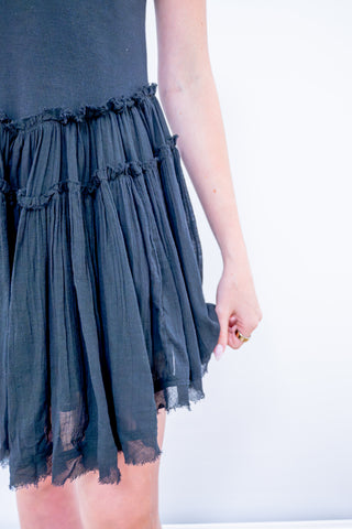 Dark blue dress with ruffled details on a white background