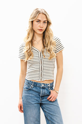 Woman wearing a striped shirt and jeans against a white background