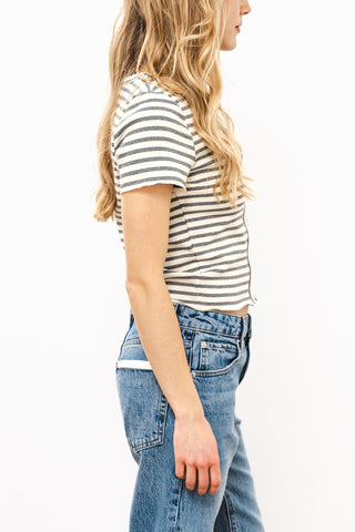 Woman wearing a striped shirt and blue jeans on a white background