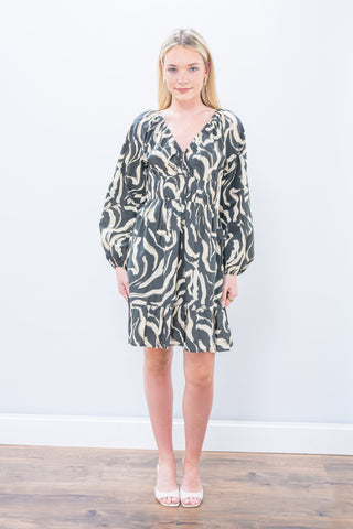 Woman wearing a patterned dress against a white background