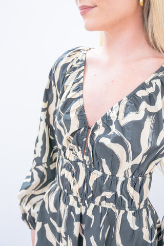 Close-up of a person wearing a patterned dress with a neutral background