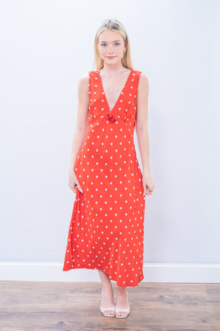 Woman wearing a red polka dot dress against a white background