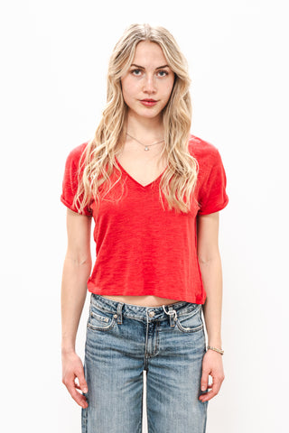 Woman wearing a red top and blue jeans on a white background