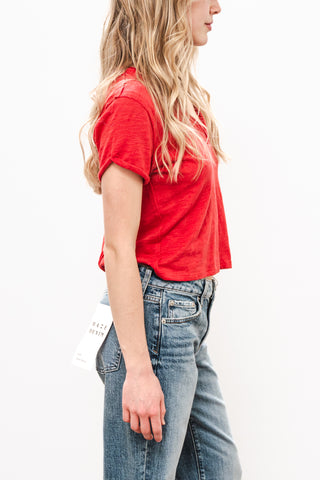 Person wearing a red t-shirt and blue jeans on a white background