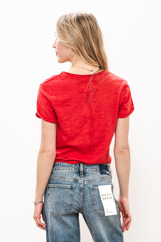 Person wearing a red t-shirt and blue jeans with a white background