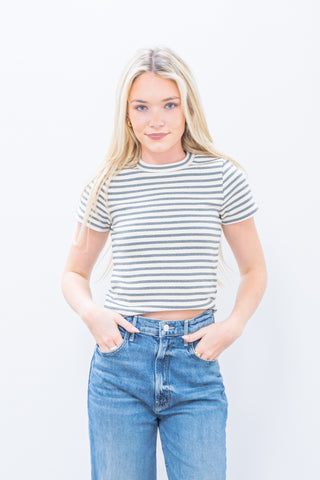 Woman wearing a striped shirt and jeans on a white background