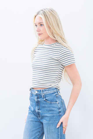 Woman wearing a striped shirt and jeans against a white background