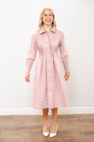 Woman wearing a pink dress with a collar against a white background